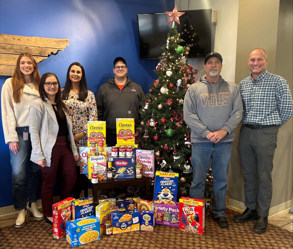 Representatives from Domtar Kingsport, United Steelworkers Local 12943, Healthy Kingsport and Kingsport City Schools’ Family Resource Center pose with donated food and household items collected during a collaborative holiday food drive.